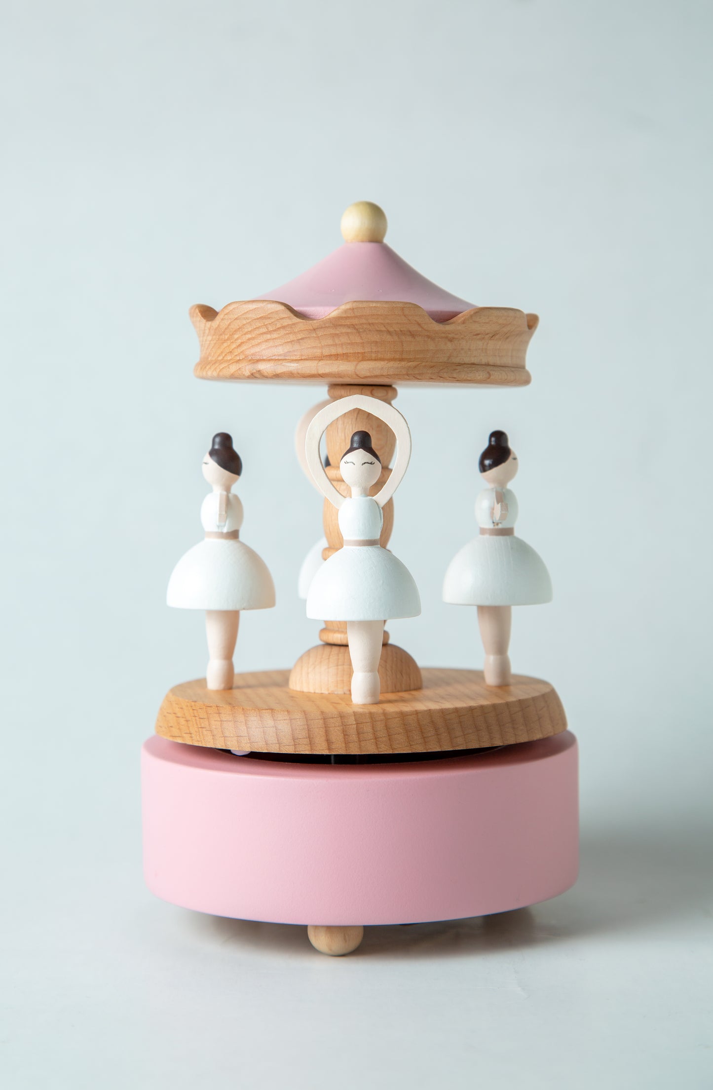 Wooden music box with ballerina figures on a light gray background