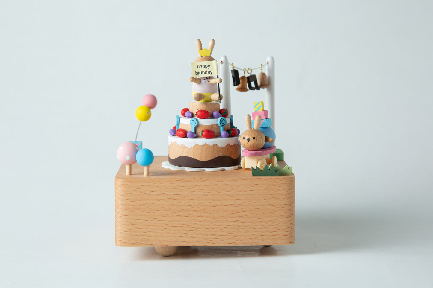 Wooden music box with a cake and rabbit design on a white background