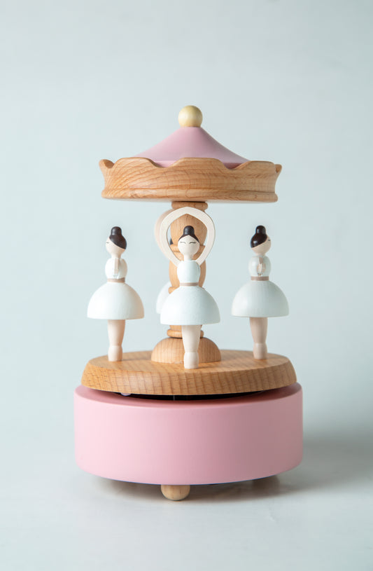 Wooden music box with ballerina figures on a light gray background
