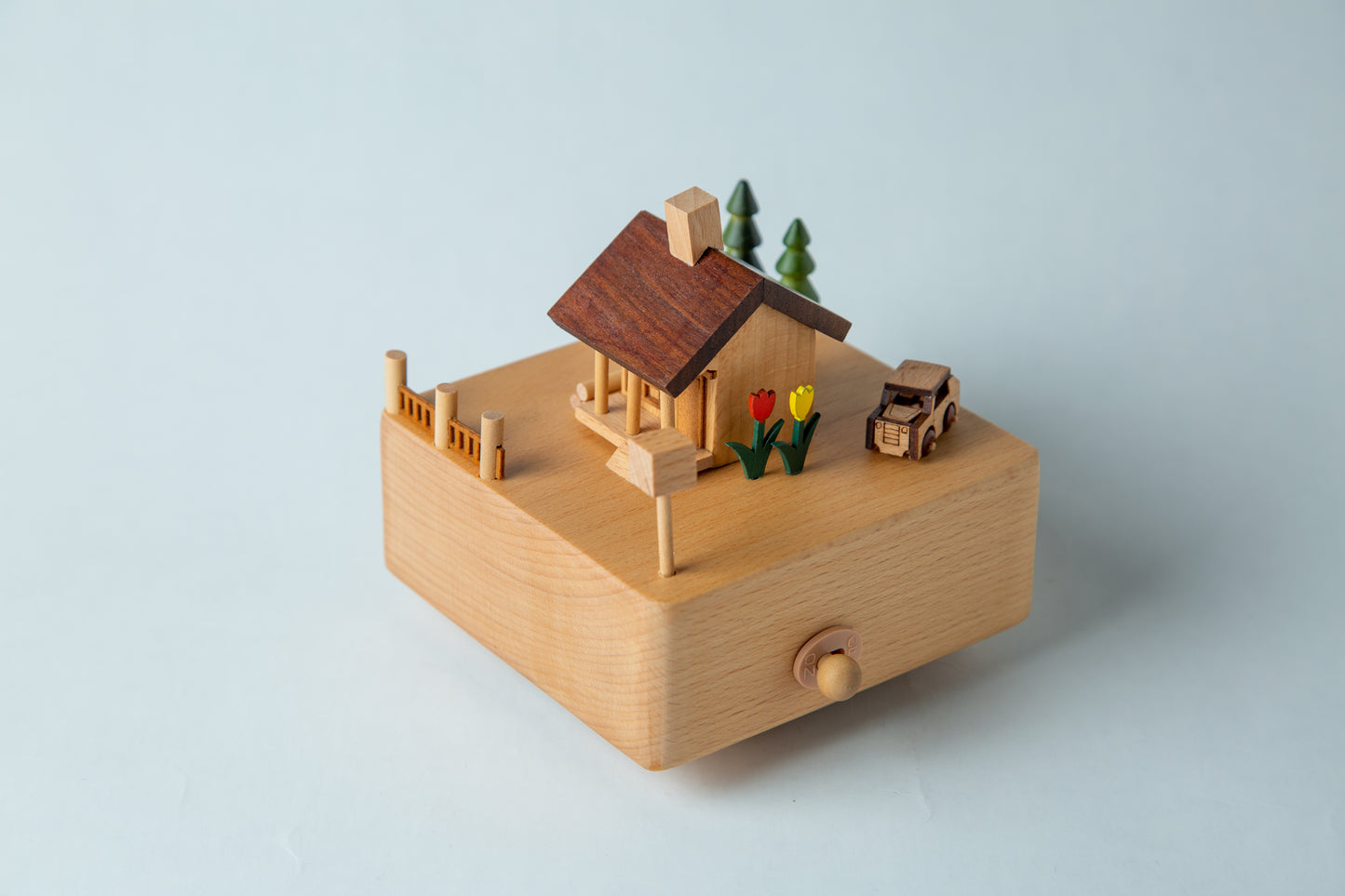 Wooden toy house with miniature accessories on a light blue background