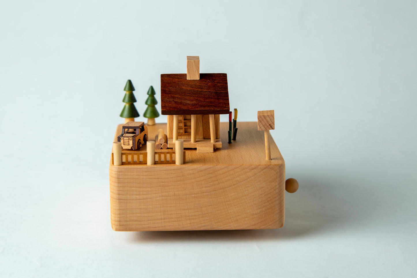Wooden model of a village with trees on a light gray background