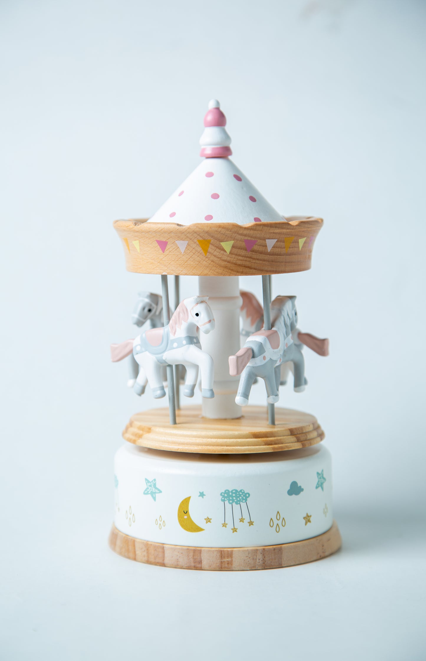 Wooden carousel toy with horses on a white background